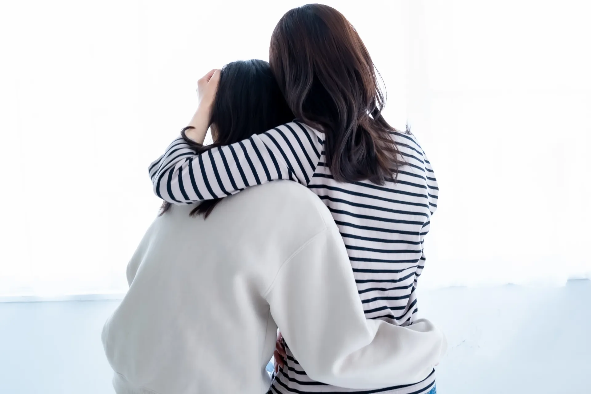 泣いている女性を抱き寄せる別の女性