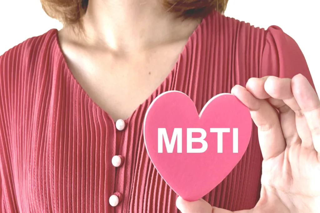 『MBTI』と書かれたハート型の札を持つ女性